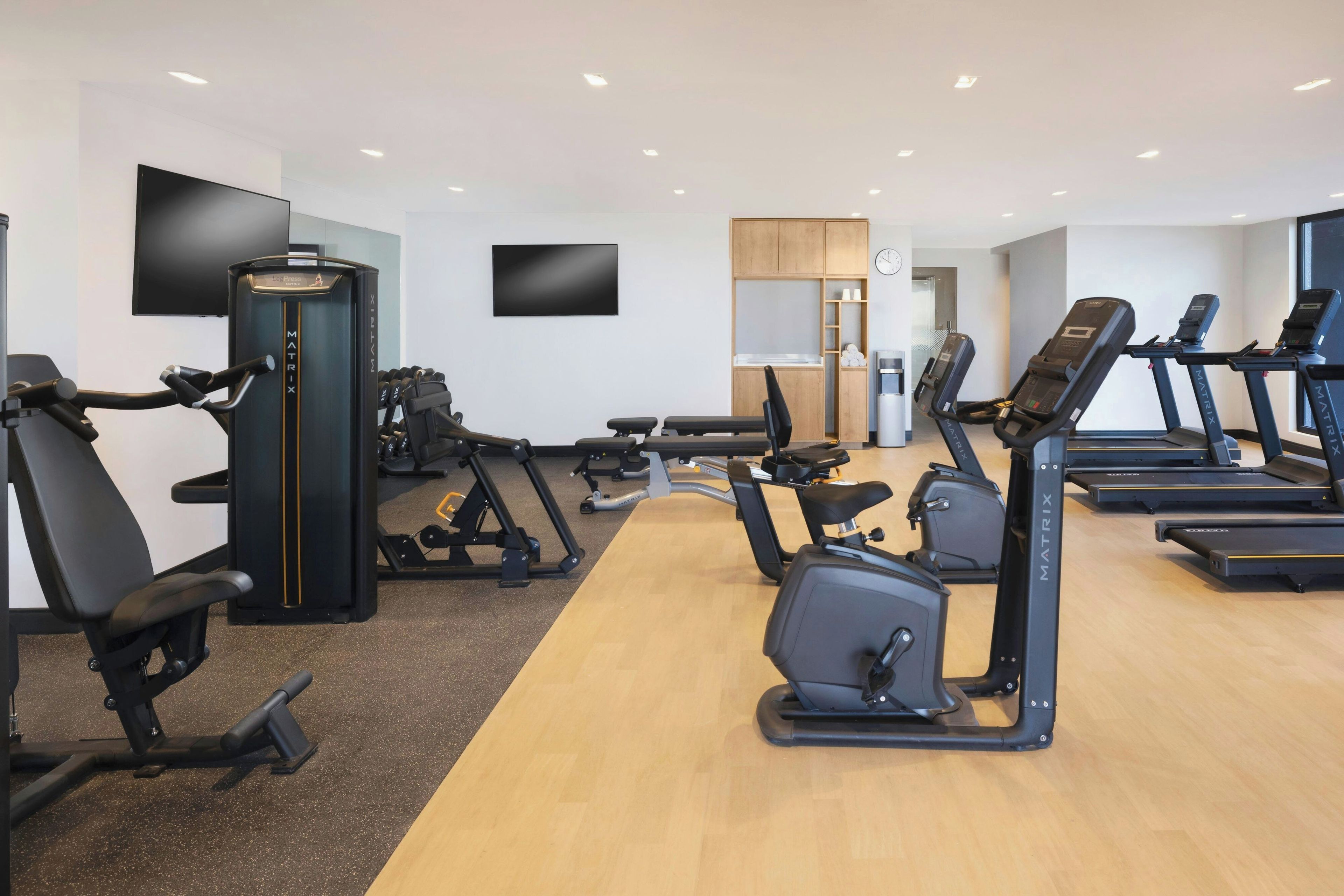 A gym with treadmills, elliptical machines, and weight equipment.