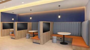 A modern seating area with built-in booths, round tables, and pendant lighting.