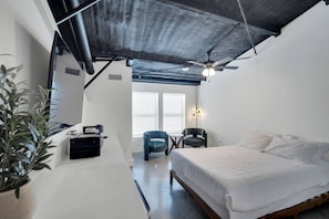 A modern bedroom with a bed, a desk, a chair, and a ceiling fan. - The Lawson Loft – Walkable DT 209 (Midlothian)
