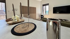 A modern living room with a flat-screen TV, a coffee table with candles, and a sofa. - Le Chai - Gervans (Gervans)
