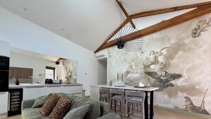 A modern living space with a sofa, dining area, and kitchen. - Le Chai - Gervans (Gervans)