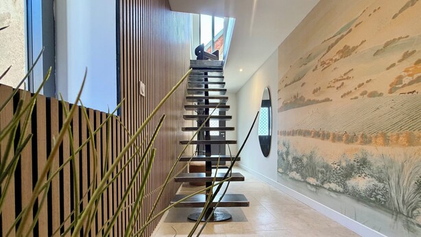 A modern interior with a staircase, a textured wall mural, and a wooden slat wall. - Le Chai - Gervans (Gervans)