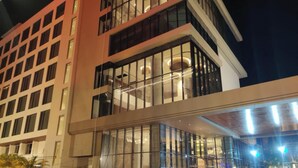 Ett hotell med flera våningar, stora fönster och en modern arkitektonisk design.