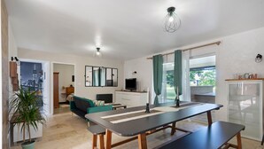 Una cocina moderna con una mesa de comedor, un sofá y un televisor.