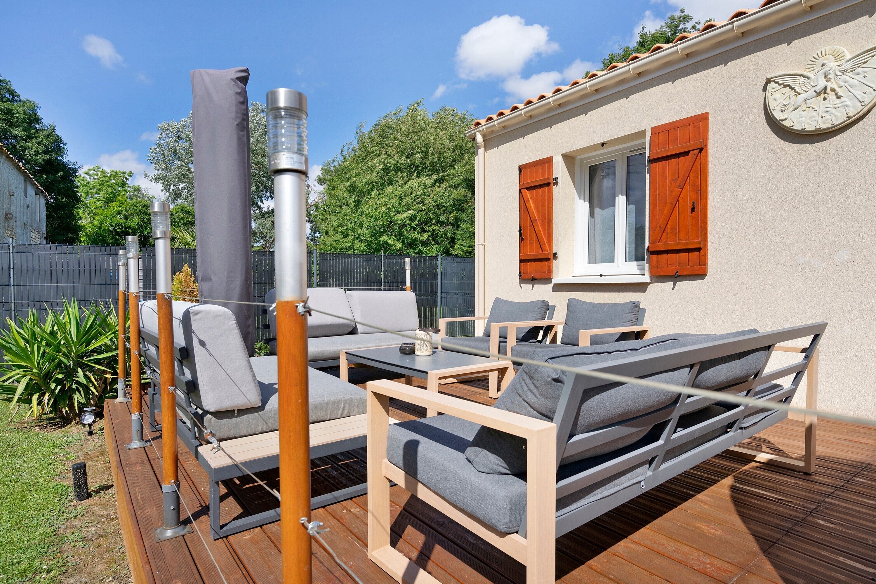 Eine Terrasss mit einer Couch, Sesseln und einem Tisch.