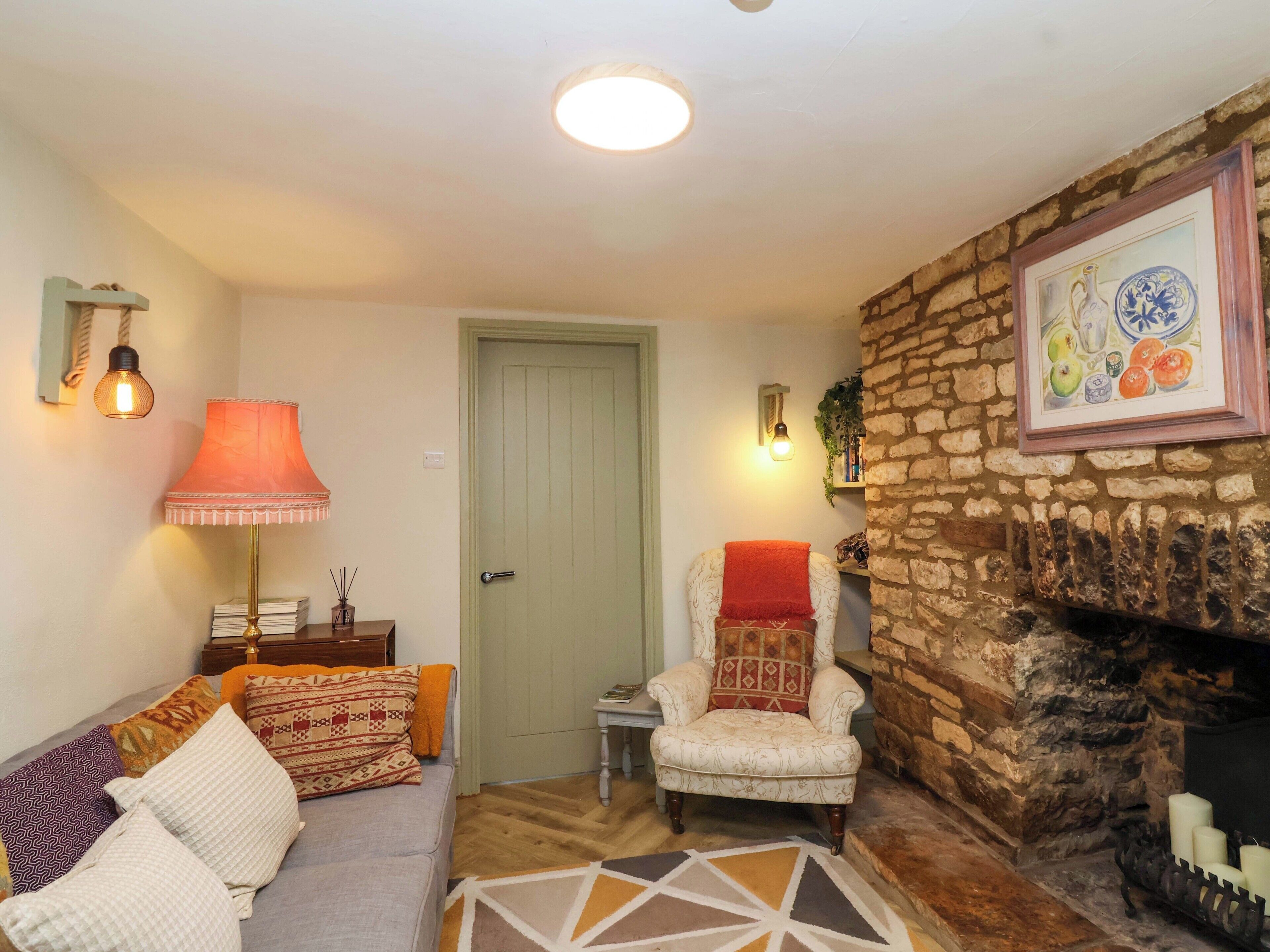 A cozy living room with a sofa, armchair, and a fireplace.
