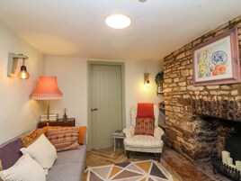 Una sala de estar acogedora con sofá, sillón y chimenea.