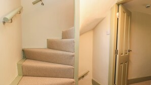 A staircase with carpeted steps leading to a door. - 29 Spring Street (Chipping Norton)