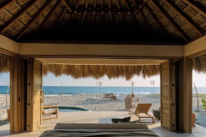 A beachside room with a wooden ceiling, a bed, and a view of the beach and ocean. - Casa Sal by Tasman (Villa de Tututepec de Melchor Ocampo)