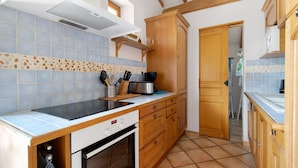Een keuken met houten kastjes, een fornuis en een vaatwasser.