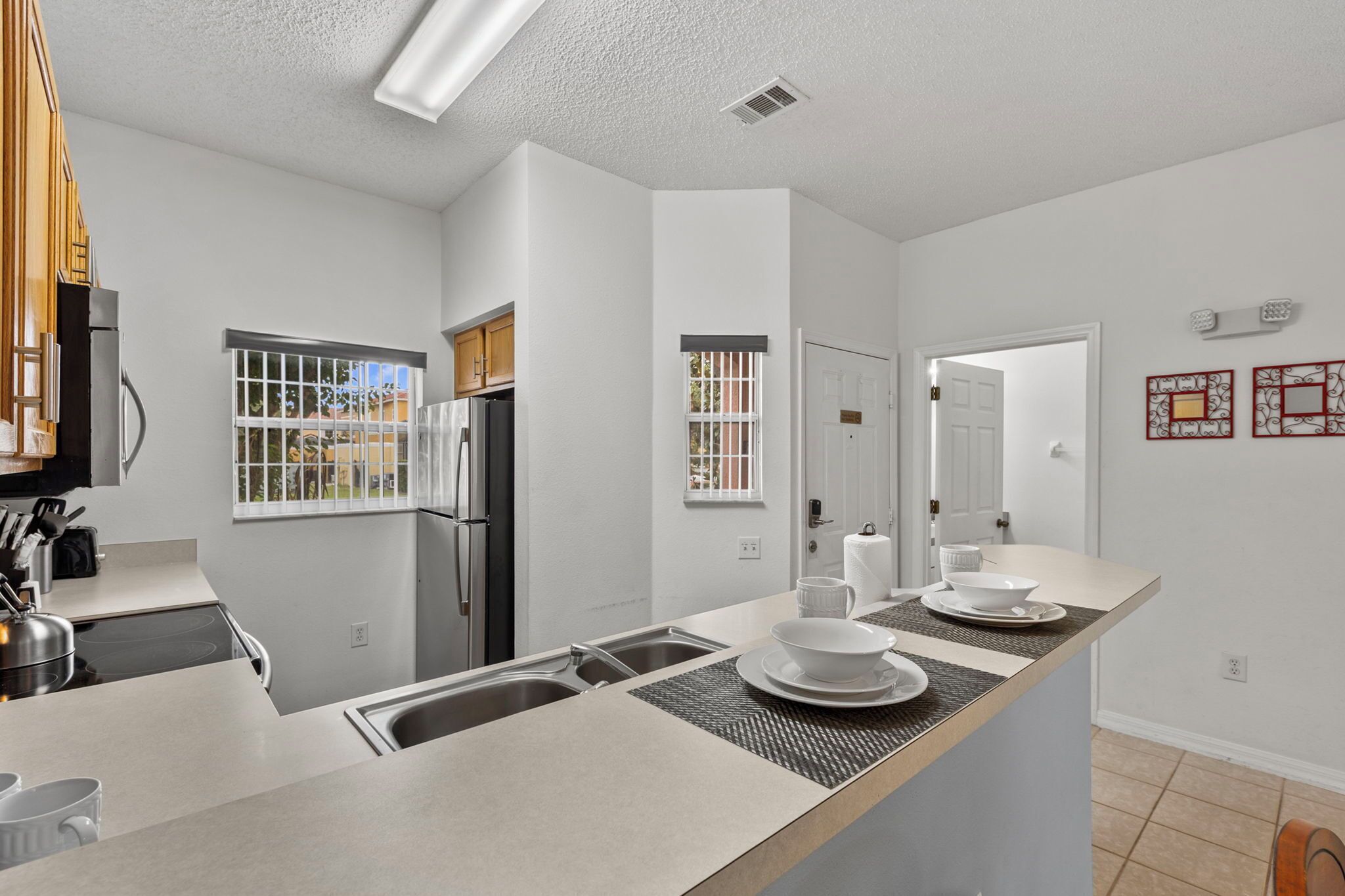 A modern kitchen with a central island, built-in appliances, and a view of the outdoors.