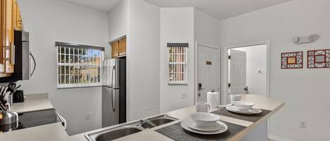 A modern kitchen with a central island, built-in appliances, and a view of the outdoors.