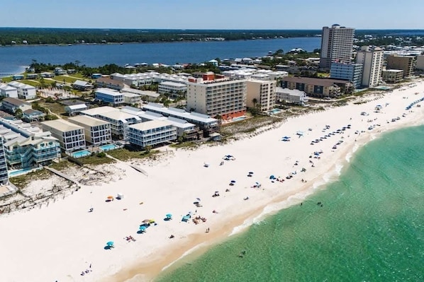 Ein Küstenhotelbereich mit Strandhäusern, einem Sandstrand und freiem Blick auf den Ozean.