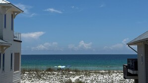 Ein Weg, der zu einem Strand mit klarem Himmel und Blick auf das Meer führt.