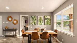 A dining area with a wooden table, six chairs, and a decorative mirror on the wall. - Near AT&T Stadium | 3/2 Home with Boho Vibes (Arlington)