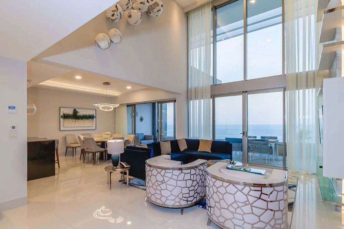 Una sala de estar moderna con sofá, mesa de centro y comedor.