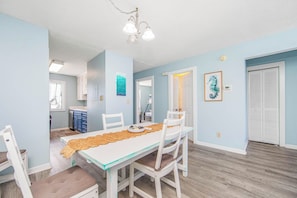A dining area with a table, chairs, and a ceiling light fixture. - The 312 at 69th Ave: Poolview Retreat (Myrtle Beach)