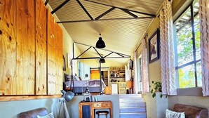 Um interior rústico com paredes de madeira, tapete de couro de vaca e poltronas de couro.