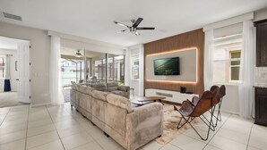 Un salon moderne avec un canapé, une table basse et un téléviseur fixé au mur.