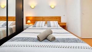 A hotel room with a bed, a nightstand, a lamp, and a mirror. - Jardin de la Vaunage, Pool & Nature, Sleeps 4 (Calvisson)