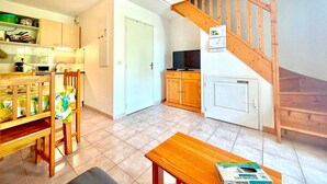 A kitchen with a dining area, a staircase, and a television. - Jardin de la Vaunage, Pool & Nature, Sleeps 4 (Calvisson)