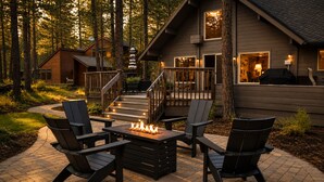 Eine Hütte mit Terrasse, Sitzgelegenheiten im Freien und einer Feuerstelle.