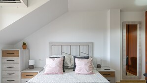 A bedroom with a bed, nightstands, a dresser, and a mirror. - Penthouse in Palmeira with Sea Views, Shared Pool, Tennis Court and Wi-Fi (Insuela)