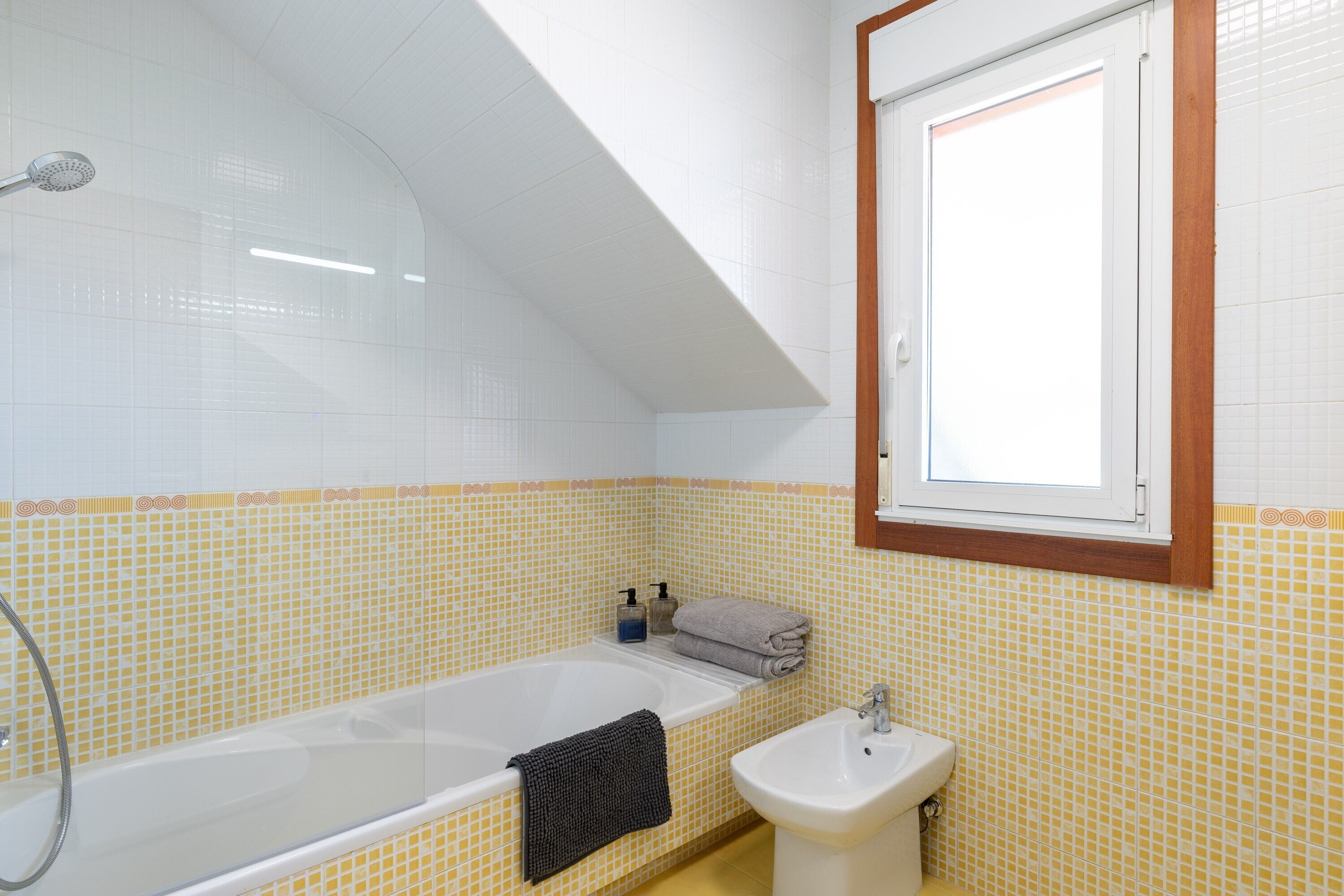 Un bagno con una vasca, un lavabo e una finestra.