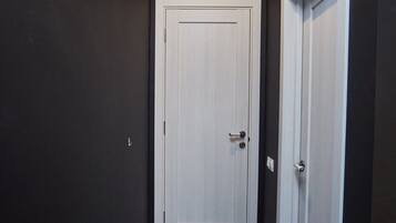 A hallway with dark walls, a white door, and a white door frame.
