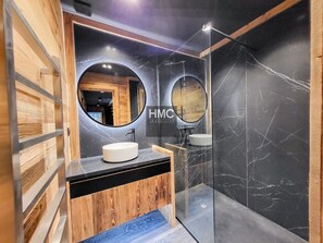 A modern bathroom with a wooden vanity, two round mirrors, and a glass shower enclosure. - Chalet "L'Oustal", superbe vue et Jacuzzi (Bolquère)