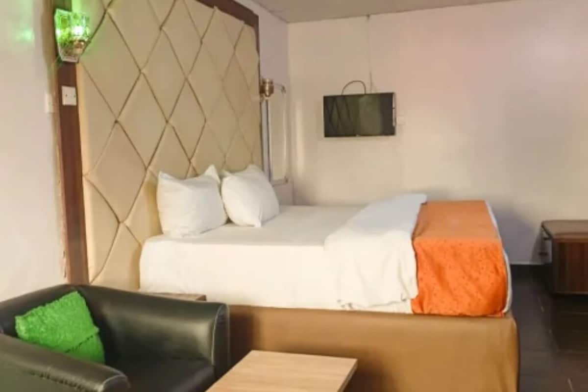 Ein Schlafzimmer mit einem Bett, einem Nachttisch, einem Sessel und einem kleinen Tisch.