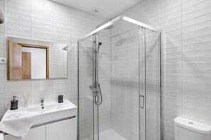 A modern bathroom with a glass-enclosed shower, a white sink with a towel, and a mirror above the sink. - Room 'Room 14 - Quinta Do Avô' with Mountain View, Wi-Fi and Air Conditioning (Ribeira)
