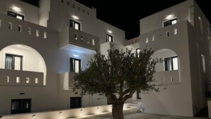 Ein Gebäude mit einem zentralen Baum, zahlreichen Fenstern und einem gepflasterten Innenhof.