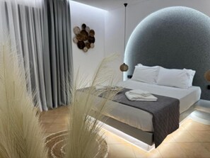 Un dormitorio moderno con una cama, cortinas, una obra de arte en la pared y un techo esférico único.