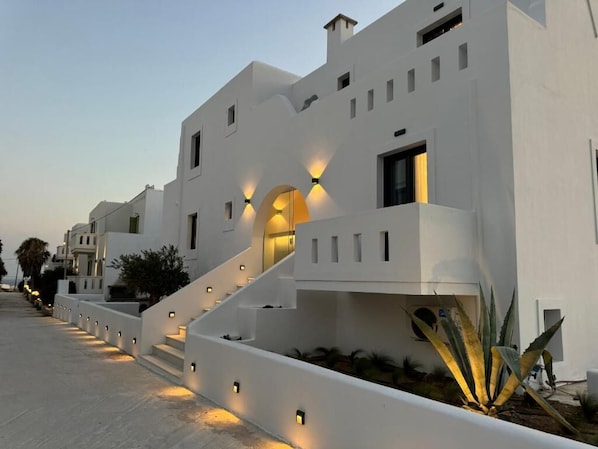 Un bâtiment moderne de couleur blanche, doté d’un escalier et d’un éclairage extérieur.
