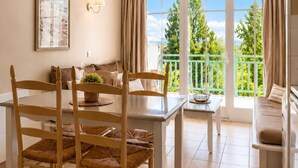 Zona pranzo con tavolo, sedie e vista sul verde attraverso ampie finestre.