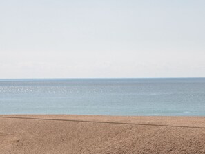 Ein Strand mit blauem Himmel und ruhiger See.