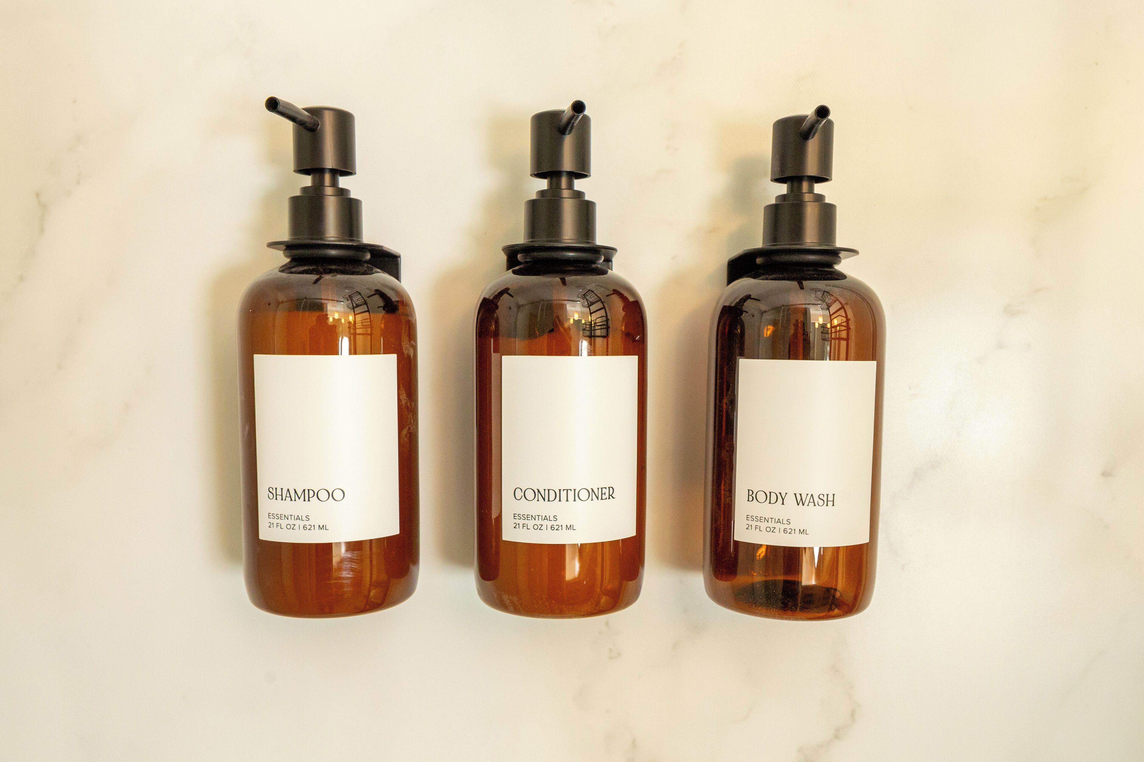 Tre flasker shampoo, balsam og showergel.