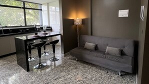 Una cocina moderna con comedor, sofá y una lámpara de pie.