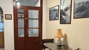 A dining area with a table, chairs, a lamp, and a door with glass panels.