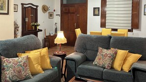 A living room with two sofas, a coffee table, a lamp, and a ceiling fan.