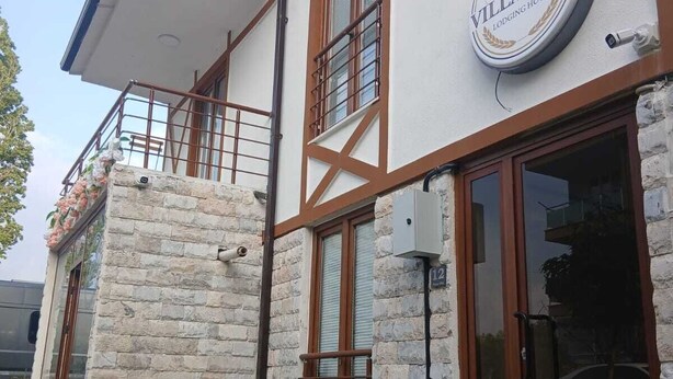 Un bâtiment à deux étages, doté d’une façade en pierre, de grandes fenêtres et d’un logo bien visible indiquant « Villa Lina ».