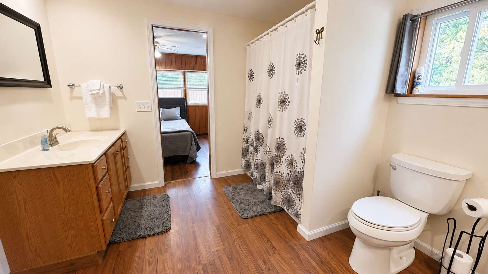 A bathroom with a toilet, sink, and shower curtain.