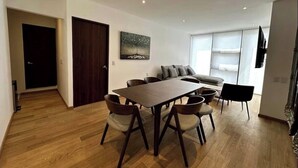 A modern living room with a dining table, sofa, and chairs. - Well located apartment, in the heart of the best Col. Roma and Col. Countess (Ciudad de México)