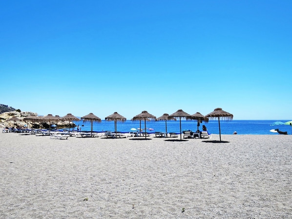 Ein Strand mit Liegestühlen und Strandkörben.