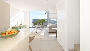 Een moderne keuken met een eethoek, uitzicht op de stad en een balkon.