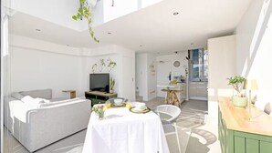 Een moderne woonkamer met een bank, eettafel en televisie.