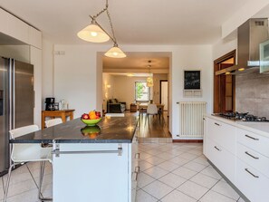 Eine moderne Küche mit Kochinsel, Edelstahlgeräten und einem Essbereich mit Aussicht.