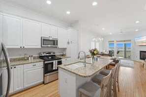 Eine moderne Küche mit weißen Schränken, Granit-Arbeitsplatten und Edelstahlgeräten.