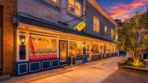 A storefront with a blue facade, a yellow sign, and a red 'OPEN' sign. - Whimsical Haven By The Springs - Wifi | Walk to Everything (Berkeley Springs)